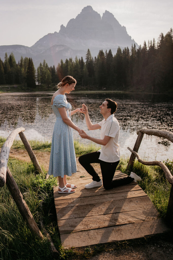 Man proposes to woman by the lake.