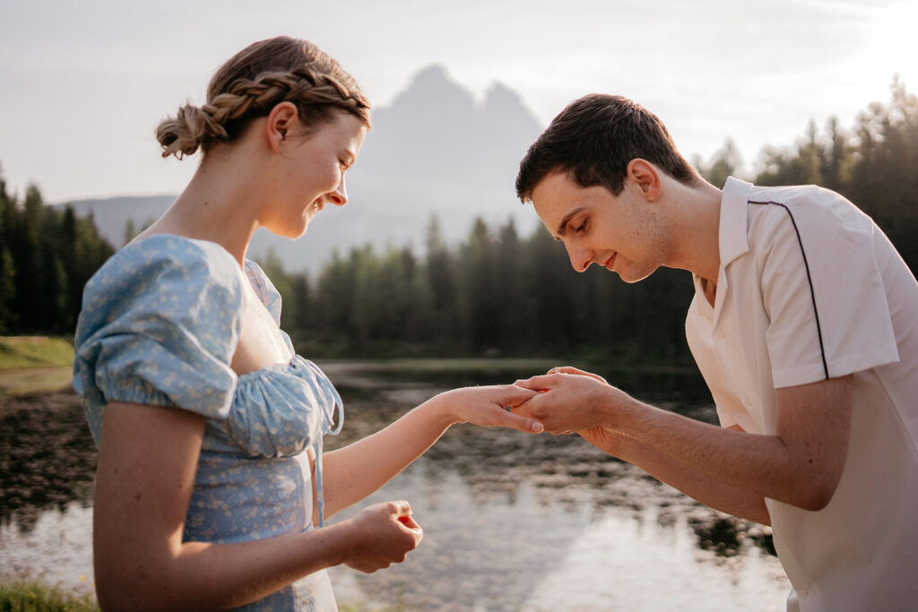 Couple by lake exchanging rings