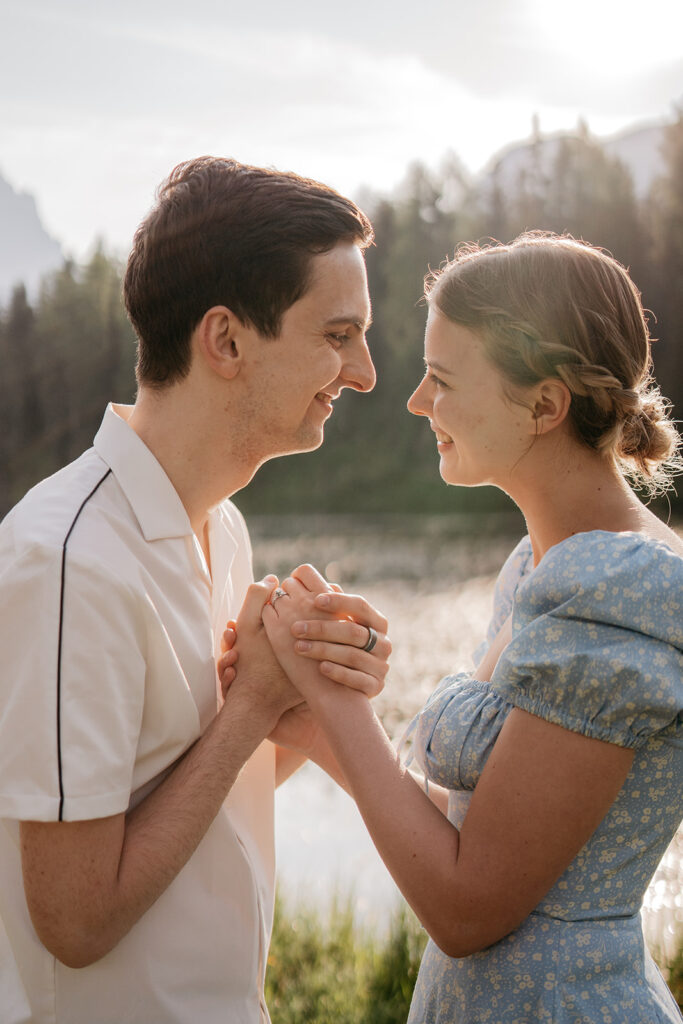 Couple smiling and holding hands outdoors.