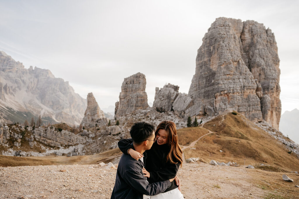 Couple embracing in scenic mountain landscape.