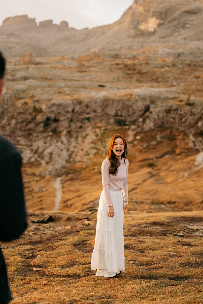 Woman smiling in a mountainous landscape.