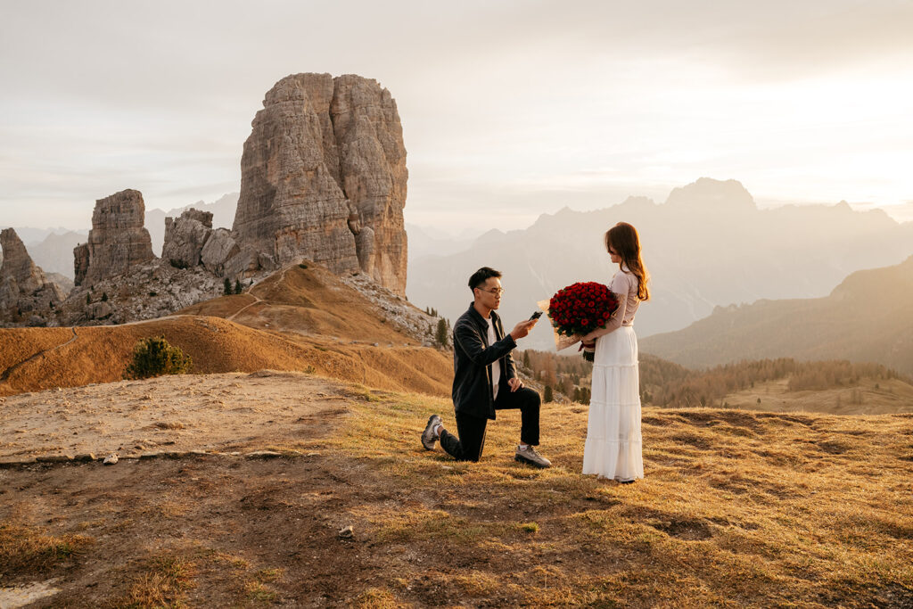 Man proposing with roses in mountain landscape