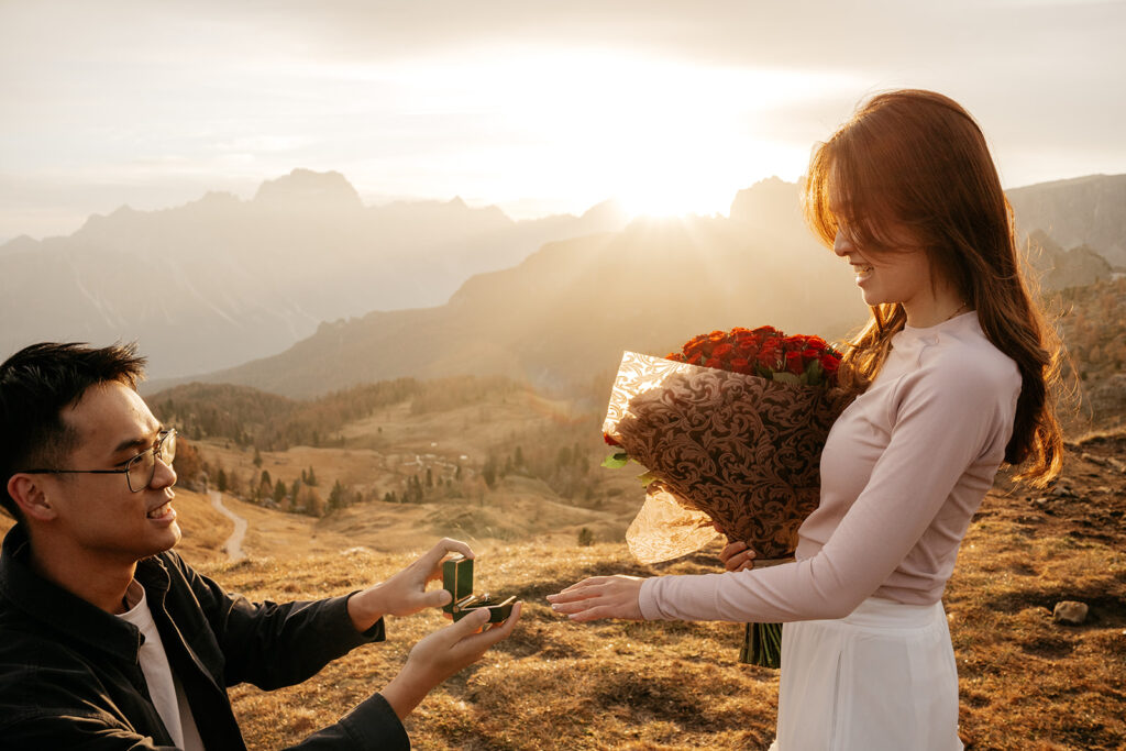 Proposal at sunset with flowers, engagement ring.