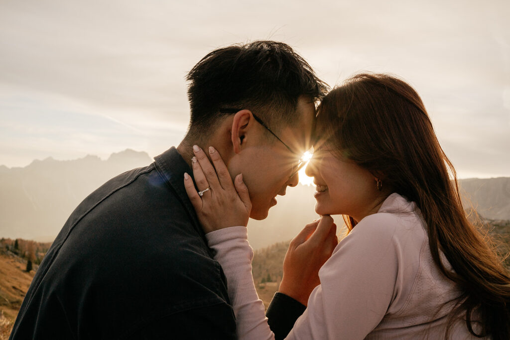 Couple embracing at sunset in scenic mountains.