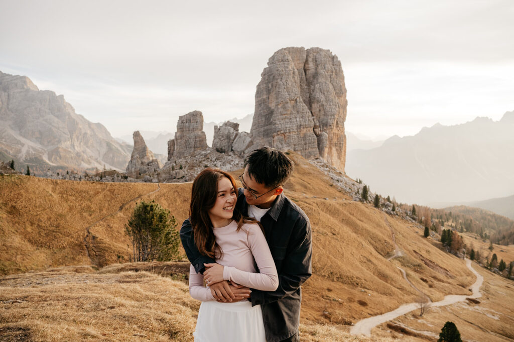 Couple embracing in scenic mountain landscape.