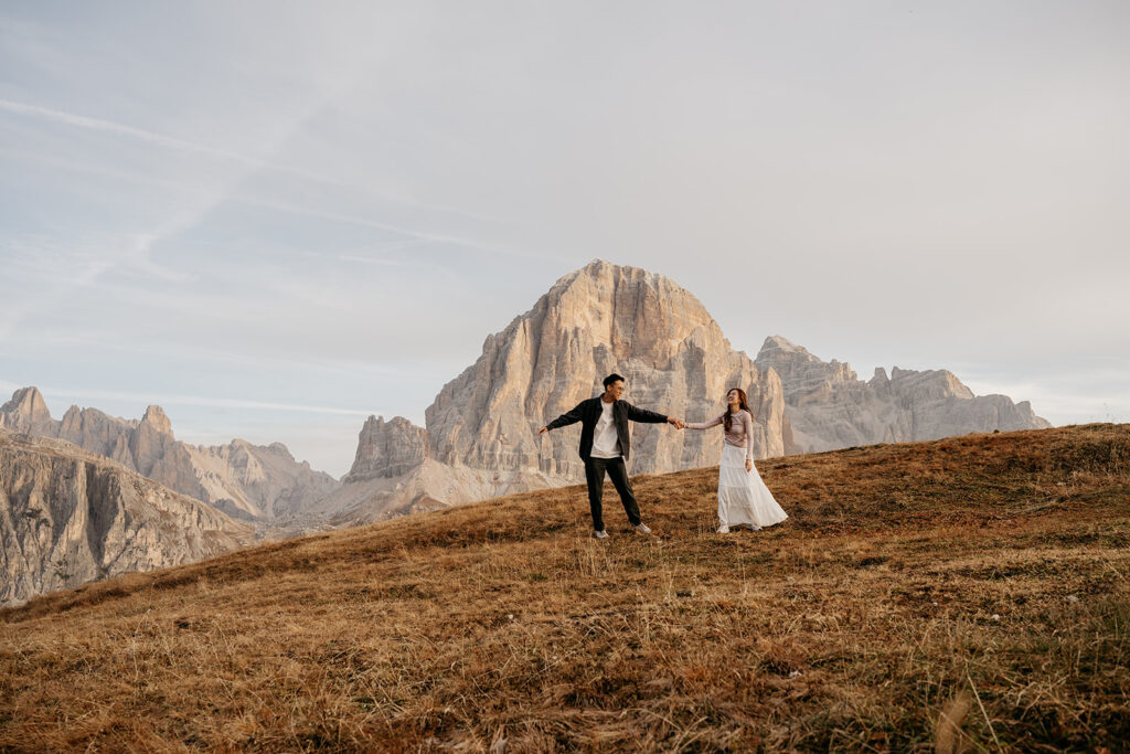 Couple holding hands in front of mountain