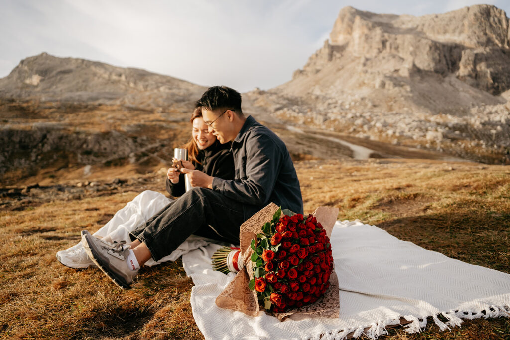 Couple enjoying picnic with roses in mountains