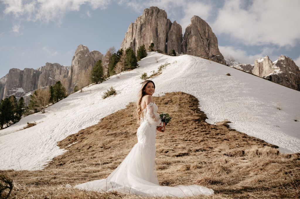 Bride smiling on snowy mountain landscape