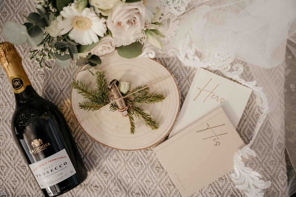 Wedding vows, prosecco, and floral arrangement on lace.