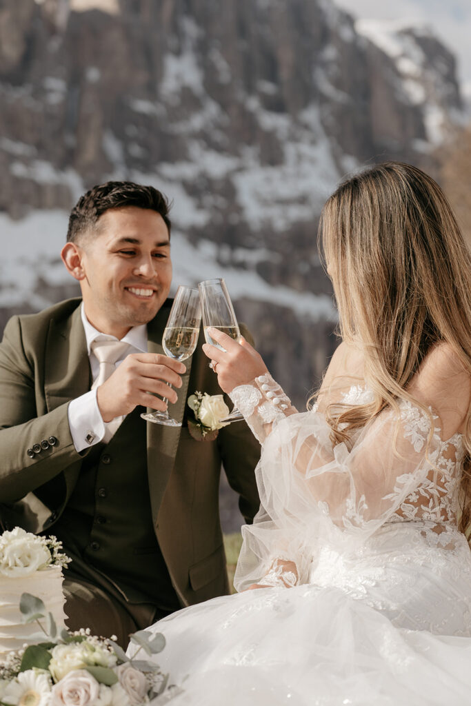 Bride and groom toasting with champagne outdoors.