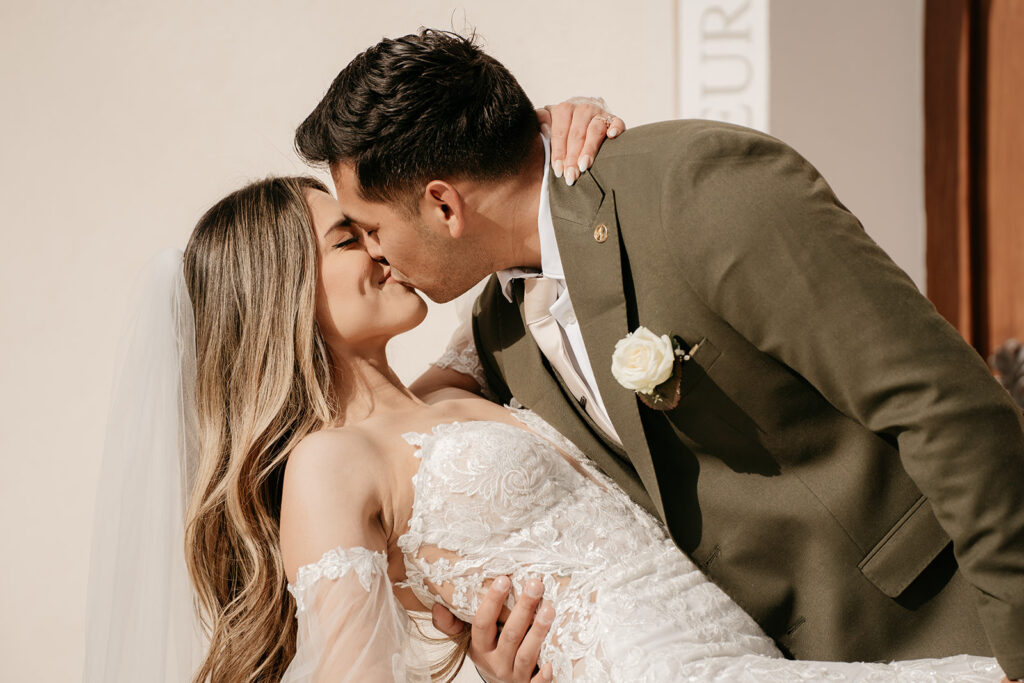 Bride and groom kissing on wedding day.