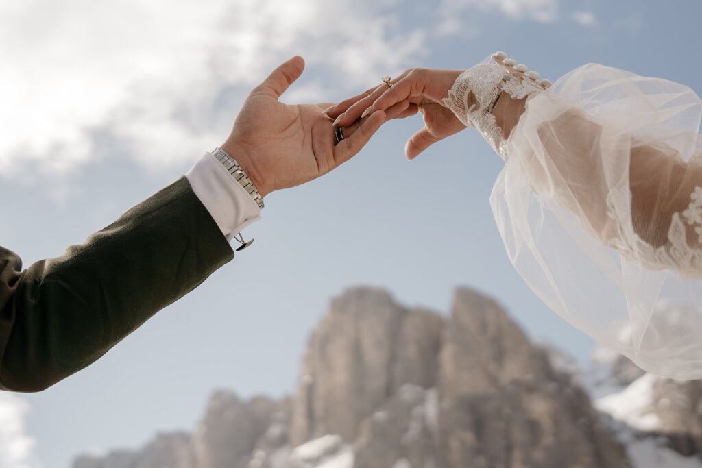 Bride and groom holding hands with mountains background.