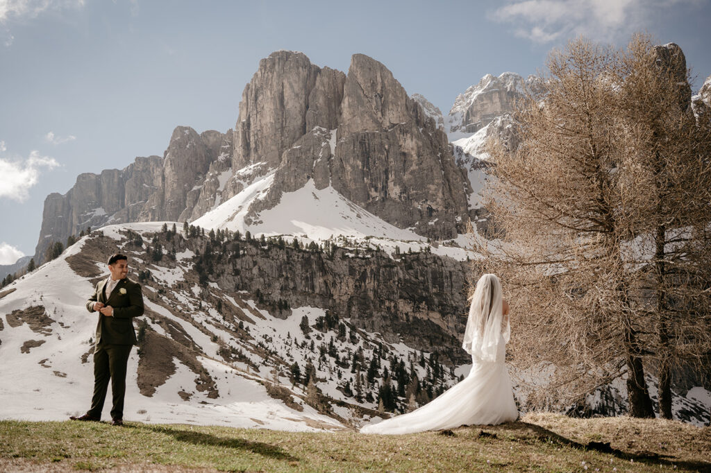 Bride and groom in snowy mountain landscape.