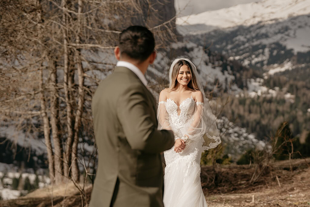 Bride and groom outdoors with mountain backdrop.