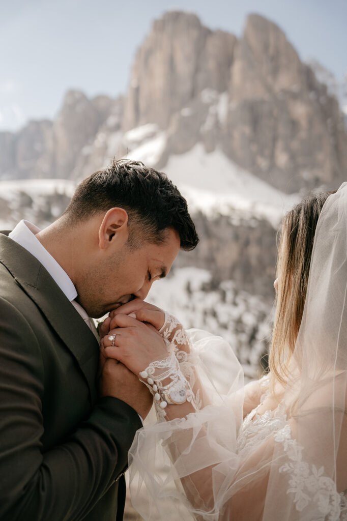 Couple embraces with snowy mountains in background.