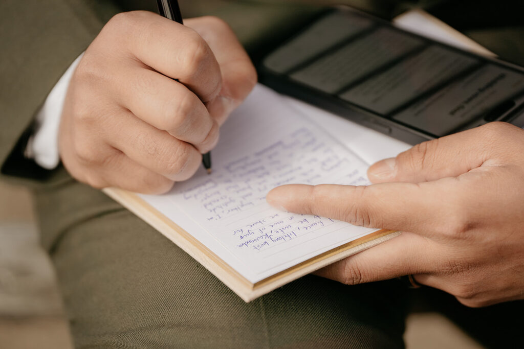 Handwriting notes in a notebook with a smartphone.