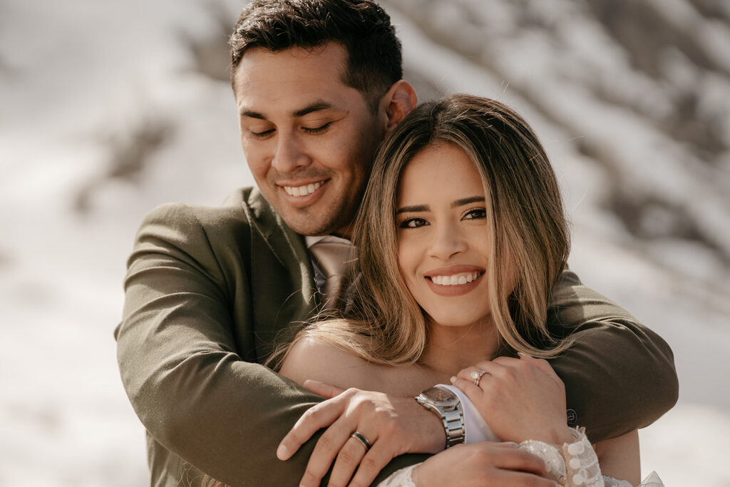 Smiling couple embracing outdoors in winter.