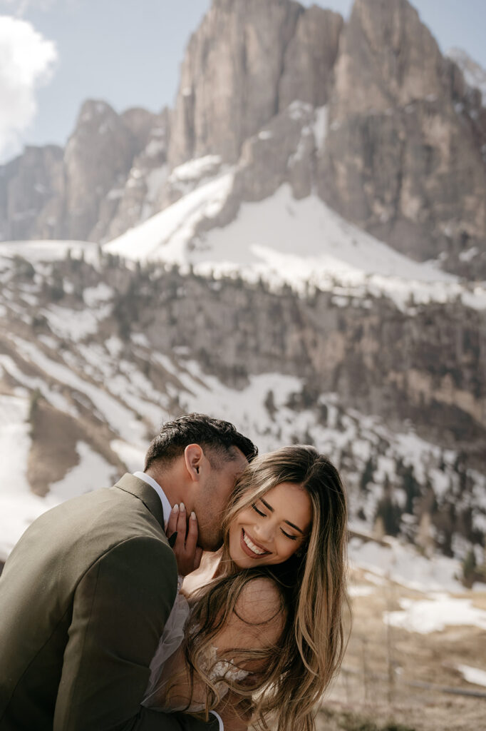 Couple embracing with snowy mountain background.