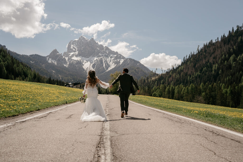 Bride and groom walking on mountain road