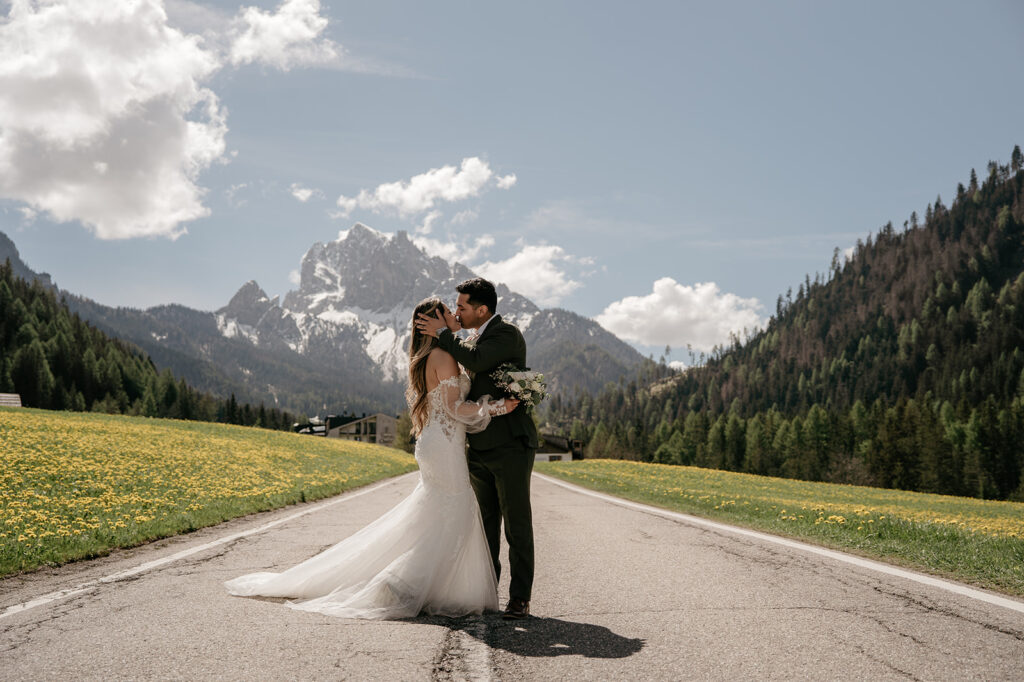 Couple kissing on mountain road with flowers