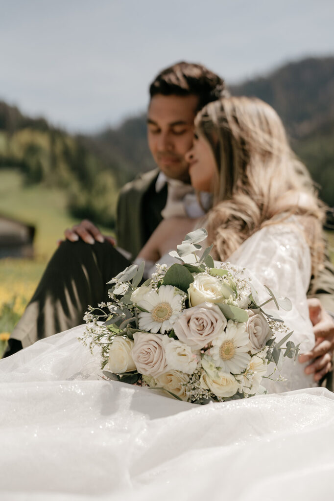 Couple embracing with bouquet in outdoor setting