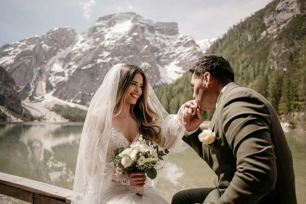 Bride and groom by scenic mountain lake.