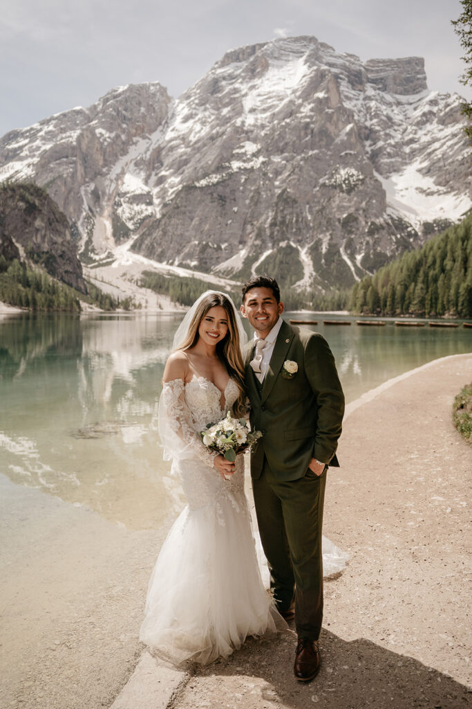 Bride and groom by scenic mountain lake.