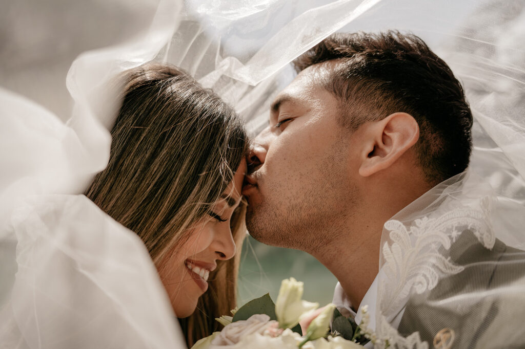 Couple under veil, intimate wedding moment