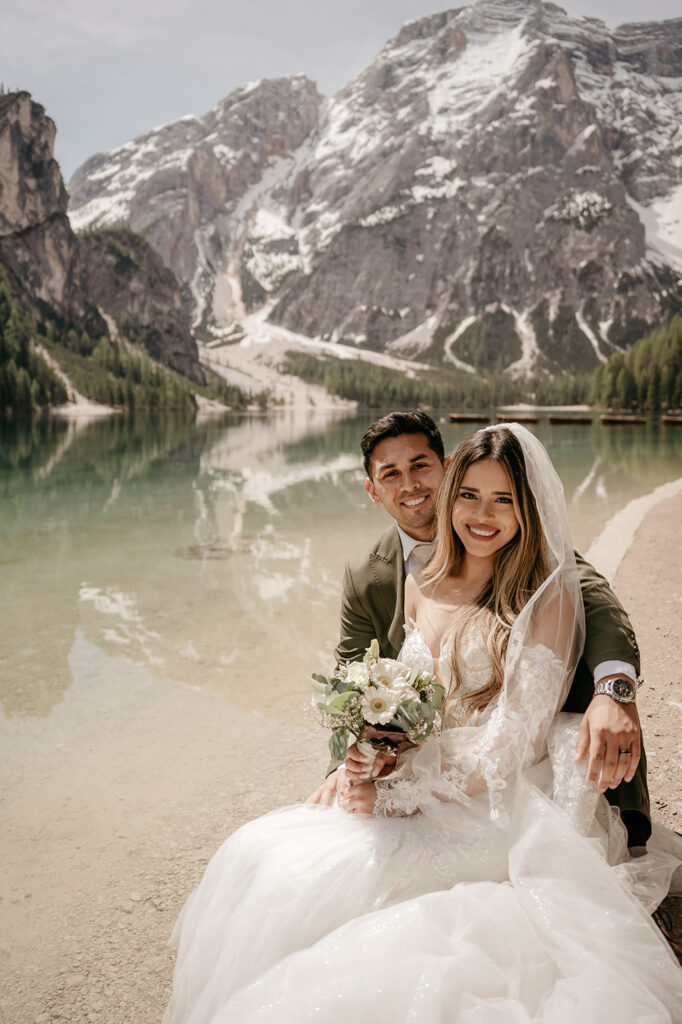 Bride and groom at snowy mountain lake