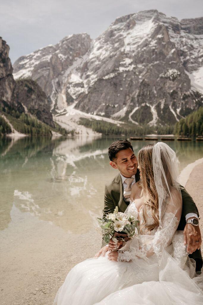 Bride and groom by mountain lake.