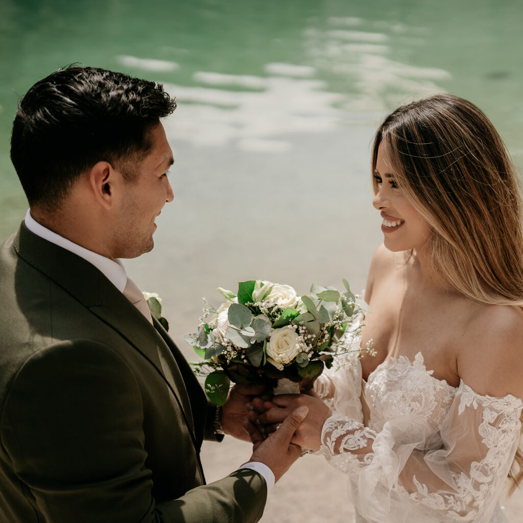 Couple exchanging vows at beach wedding ceremony.