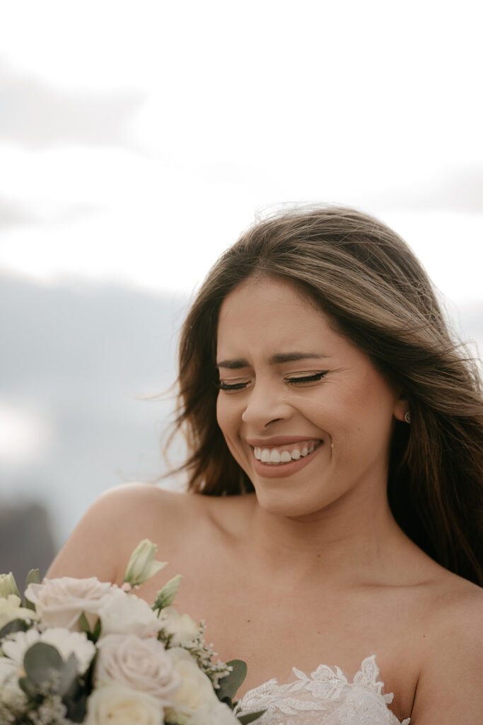 Smiling bride with bouquet, outdoors.