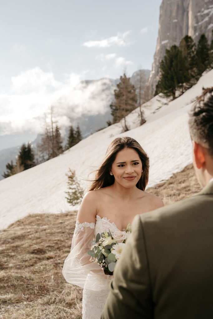 Bride and groom in snowy mountain setting.