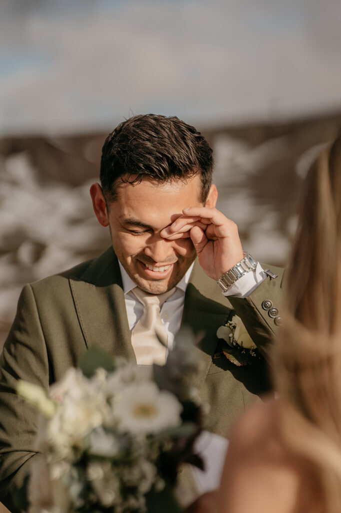 Groom smiling during outdoor wedding ceremony