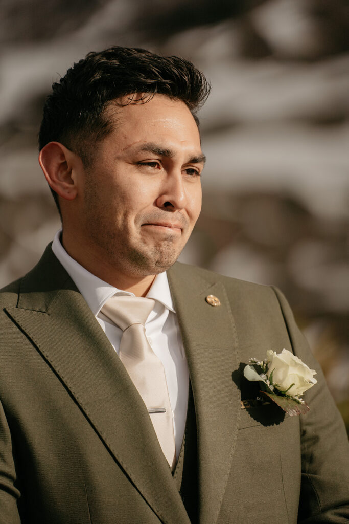 Man in suit with boutonnière, outdoors.