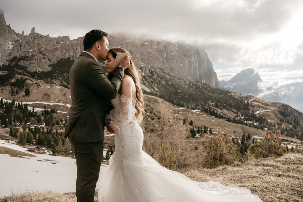 Couple embraces in scenic mountain wedding setting.