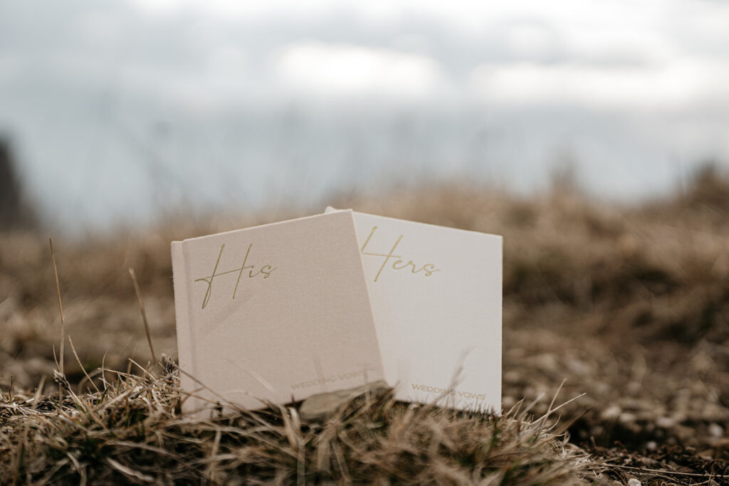 His and Hers wedding vow books on grass.