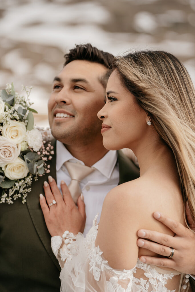 Smiling bride and groom holding flowers