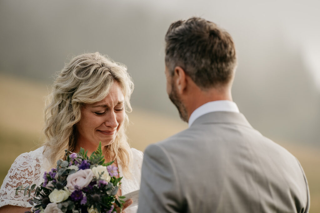 Bride reading vows, emotional moment at outdoor wedding.