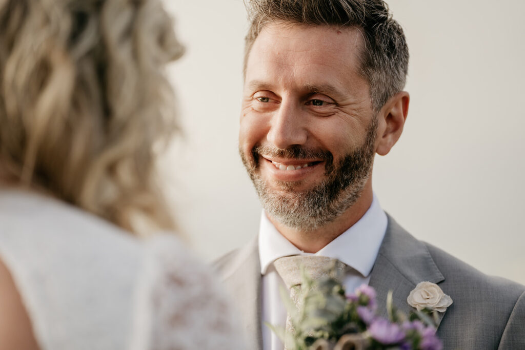 Smiling groom holding flowers at wedding ceremony