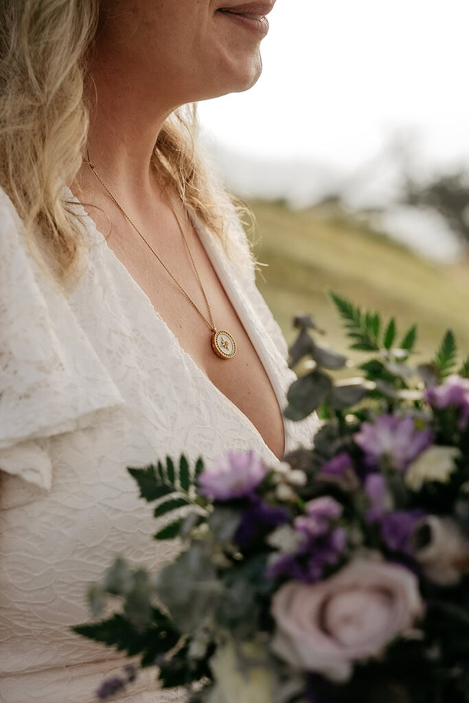 Bride in white holding purple bouquet