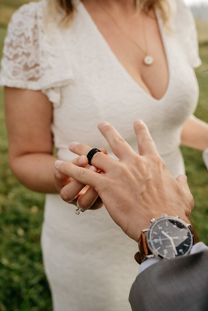 Couple exchanging rings during wedding ceremony.