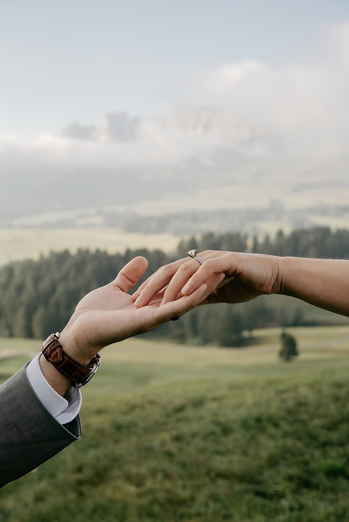 Hands touching with engagement ring outdoors