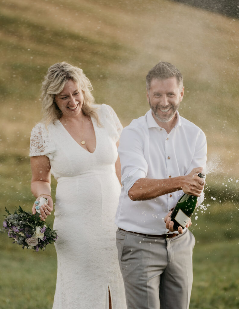 Couple celebrating with champagne outdoors