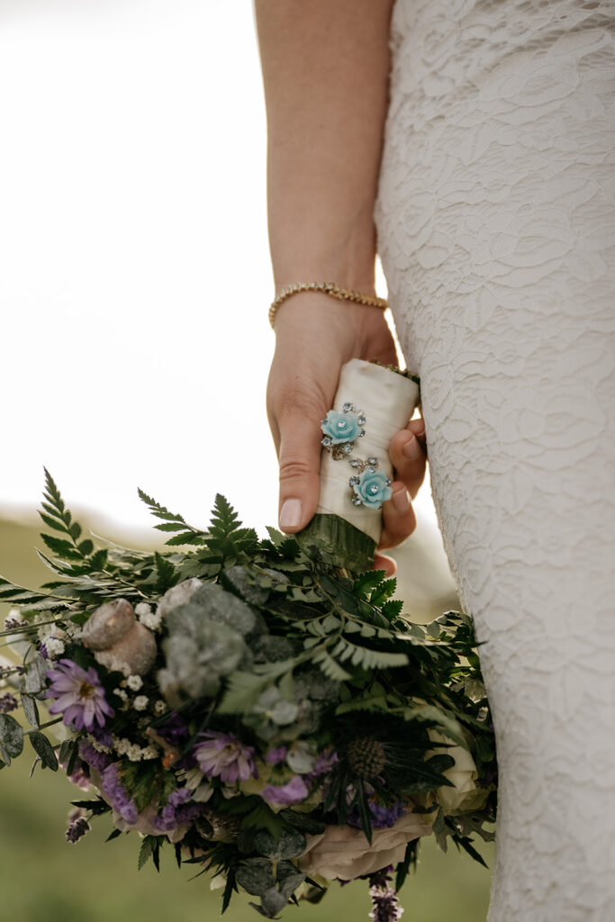 Bride holding floral bouquet with lace dress