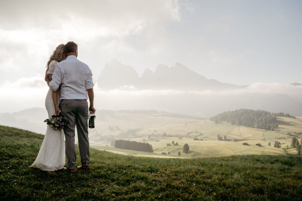 Couple embraces in scenic mountain landscape.