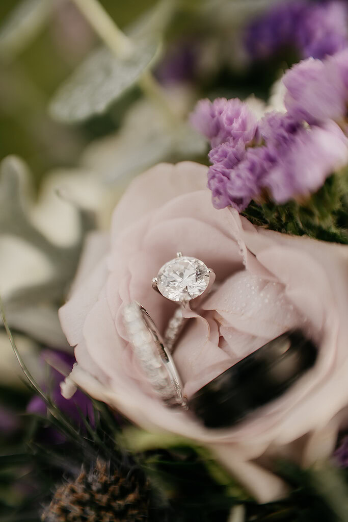 Diamond ring on pink rose with purple flowers