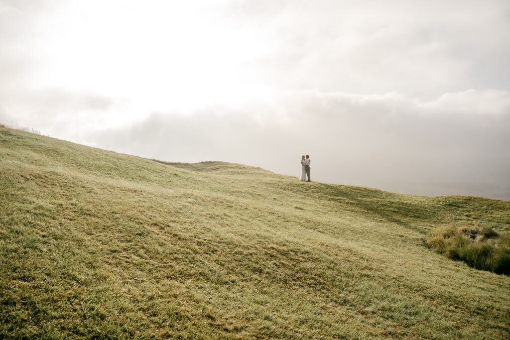 Couple embracing on a sunny hilltop