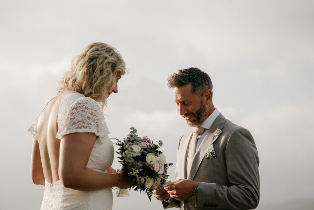 Bride and groom exchanging vows outdoors.