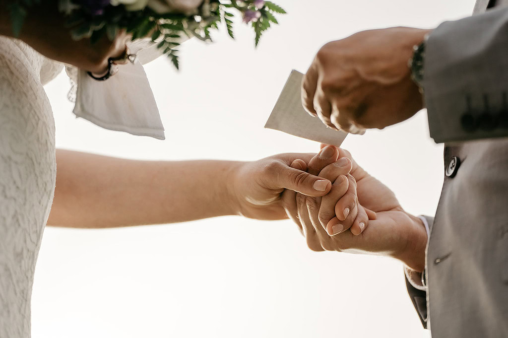 Couple holding hands during wedding ceremony.